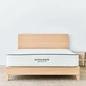 Avocado City bed frame with headboard in blonde wood finish, featuring a mattress with visible Avocado logo, styled in a minimalist bedroom setting.