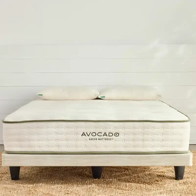 Avocado Foundation Low Profile 1 Avocado Foundation Low Profile mattress on a modern wooden base, featuring organic materials and eco-friendly design, with two pillows on top.