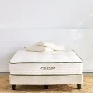 Avocado Foundation Standard mattress displayed on a bed frame with decorative pillows, highlighting eco-friendly sleep solutions from Healthy ZZZ's.