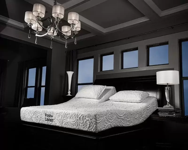 Posh + Lavish Restore 1 Posh + Lavish Restore mattress in a luxurious bedroom setting, featuring adjustable split head design, premium foam layers, and elegant decor elements like a chandelier and modern lamp.