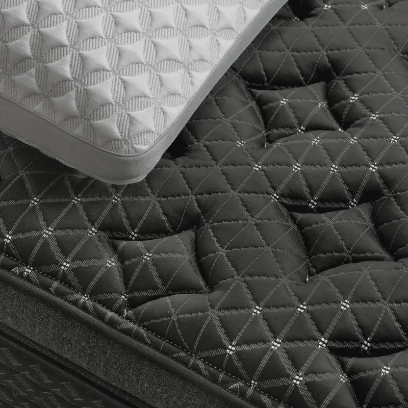 Helix Twilight Elite 3 Helix Twilight Elite mattress corner featuring quilted black fabric and a white cooling pillow, designed for firm comfort and support for side sleepers.