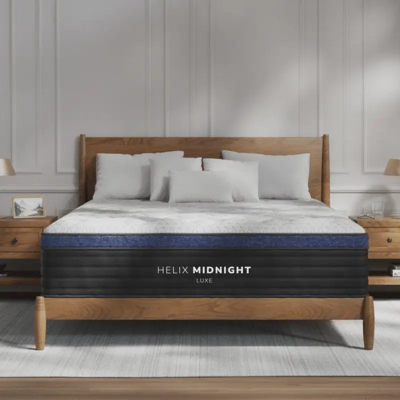 Helix Midnight Luxe 2 Helix Midnight Luxe mattress on a wooden bed frame with white and gray bedding, featuring a medium feel for side sleepers, designed for comfort and support.