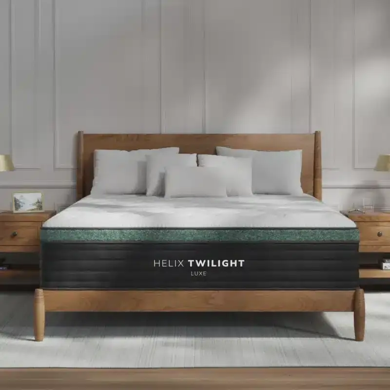 Helix Twilight Luxe mattress displayed on a wooden bed frame with decorative pillows, showcasing premium sleep solutions available at Healthy Zzz’s Sleep Store in Hamilton, OH.