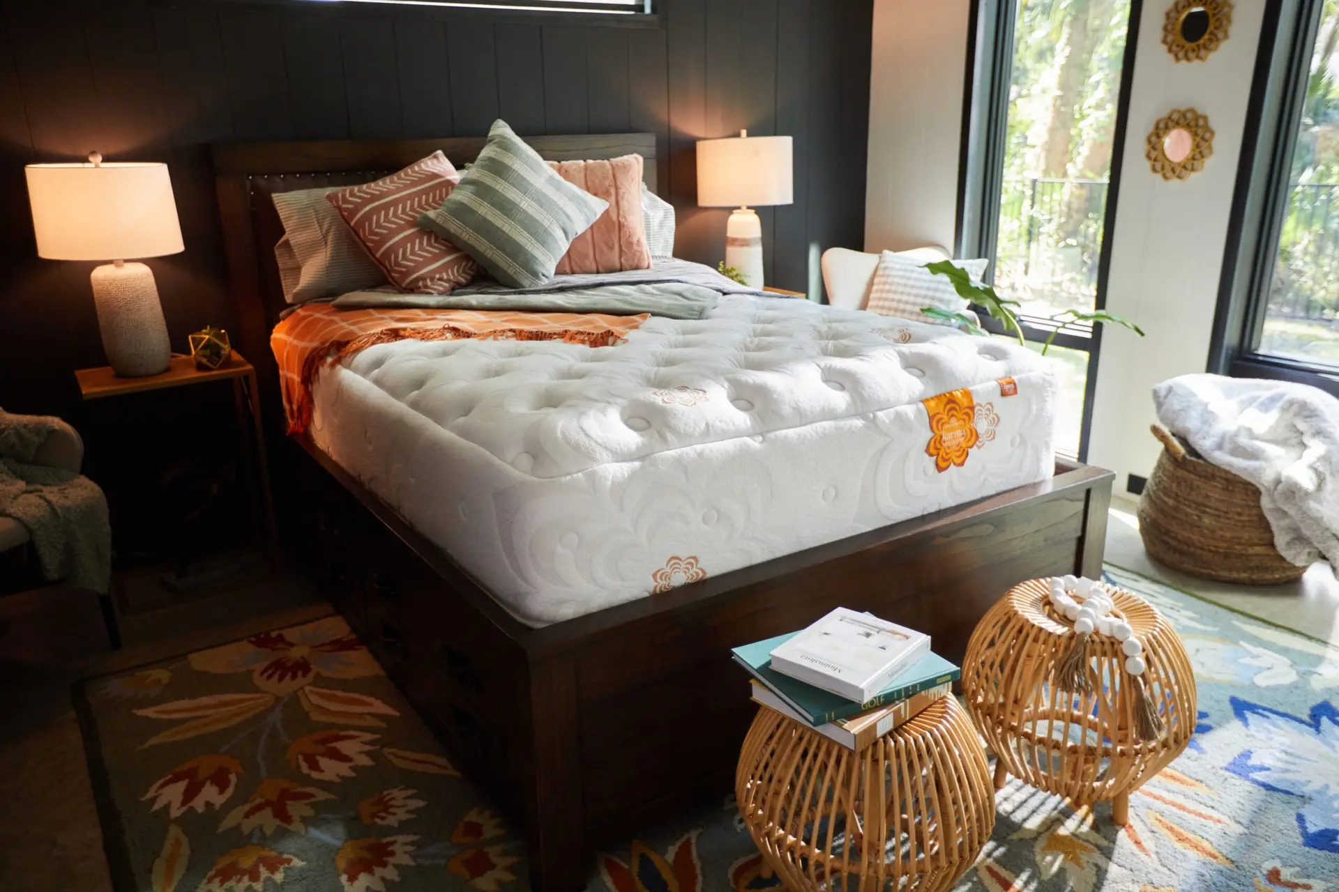 Cozy bedroom featuring a luxurious PranaSleep mattress on a wooden bed frame, adorned with decorative pillows and a warm throw, complemented by stylish side tables and natural light from large windows.