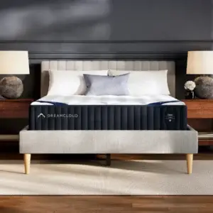 DreamCloud Classic Hybrid mattress displayed on a stylish bed frame with decorative pillows and lamps, showcasing its design and comfort features.