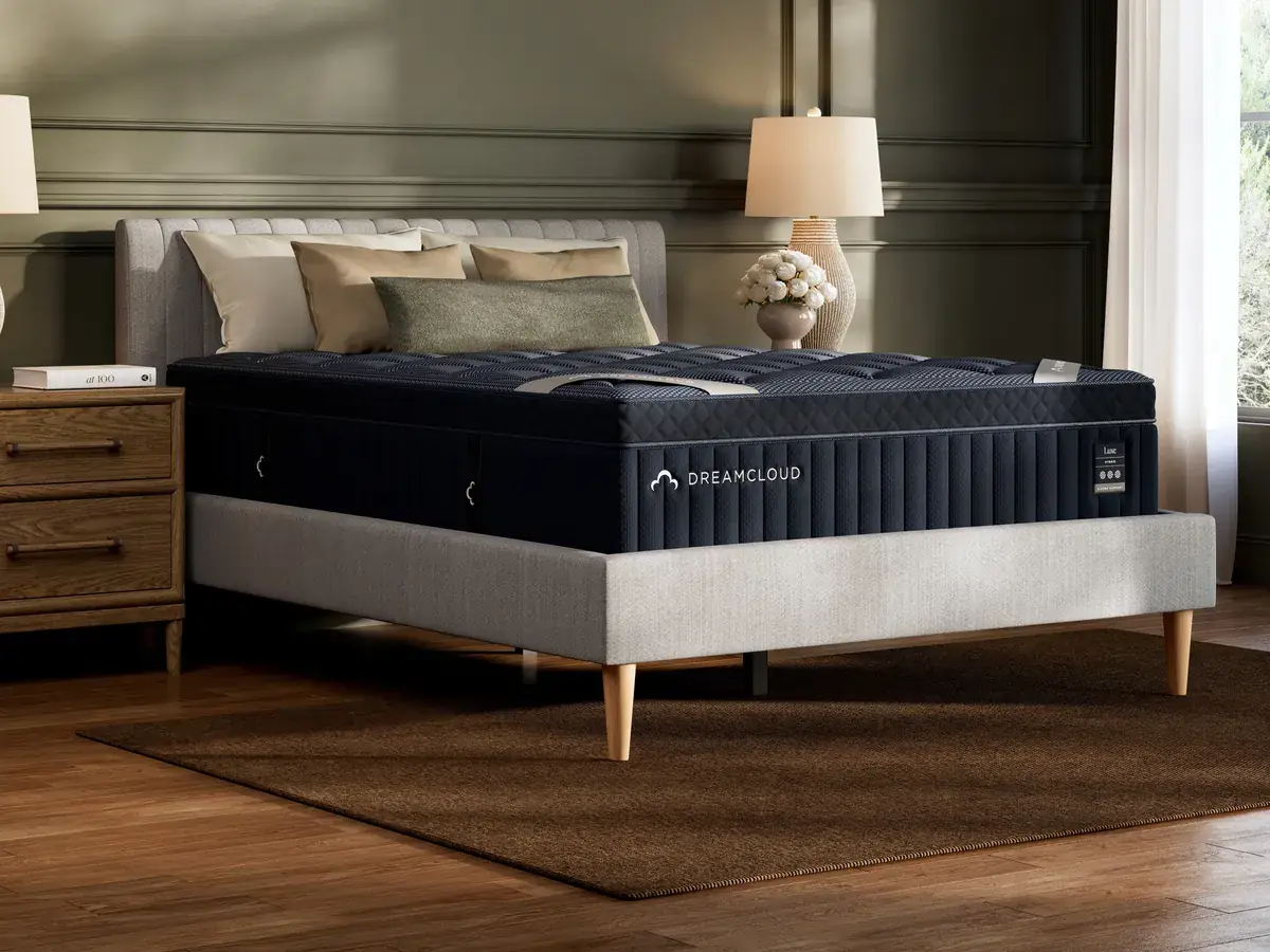DreamCloud Luxe Hybrid mattress on a stylish bed frame in a cozy bedroom setting, showcasing premium design and comfort, aligned with Healthy Zzz’s focus on high-quality sleep products.