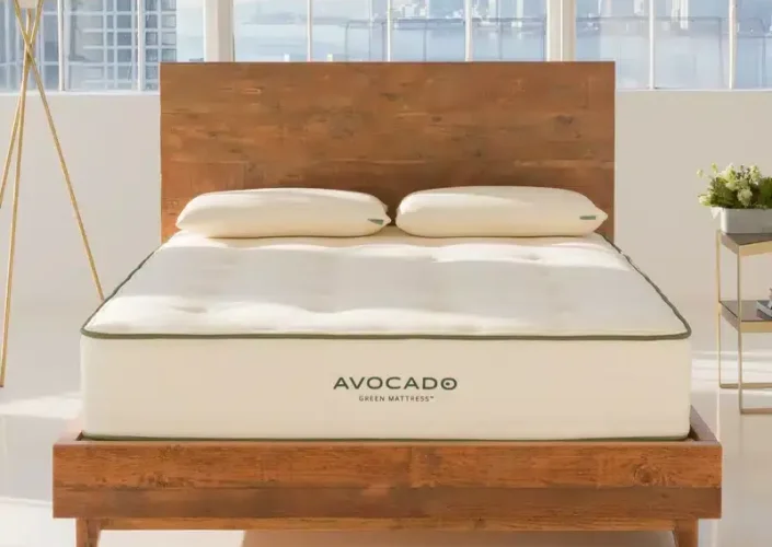 Avocado Green mattress on a wooden bed frame in a bright, modern setting, showcasing organic materials and handcrafted luxury for healthier sleep.