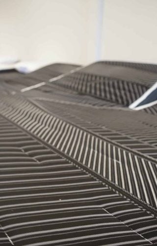 Close-up of a textured mattress surface with black and white striped patterns, emphasizing comfort and quality for health-conscious consumers at Healthy ZZZ's Sit & Sleep.