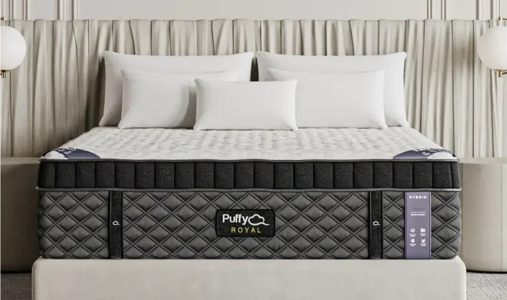 Puffy Royal Hybrid Mattress featuring a luxurious design with a quilted cover, positioned on a stylish bed frame, complemented by decorative pillows and a soft backdrop.