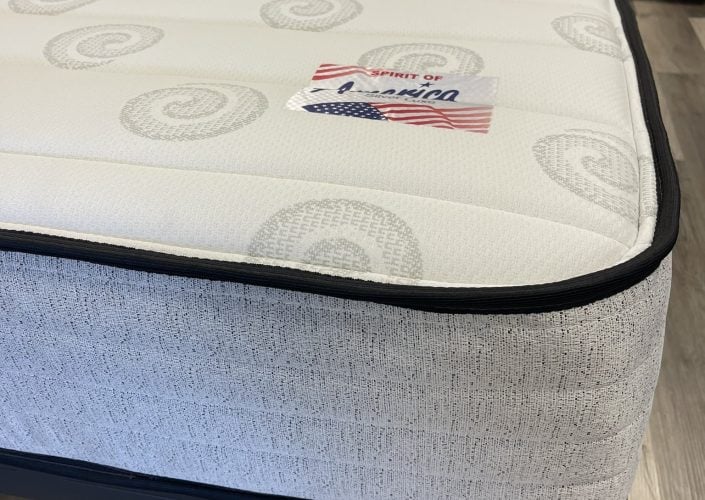 Silver Lux Plush mattress with a quilted top featuring spiral patterns and a "Spirit of America" label, designed for comfort and support, ideal for various sleeping positions.
