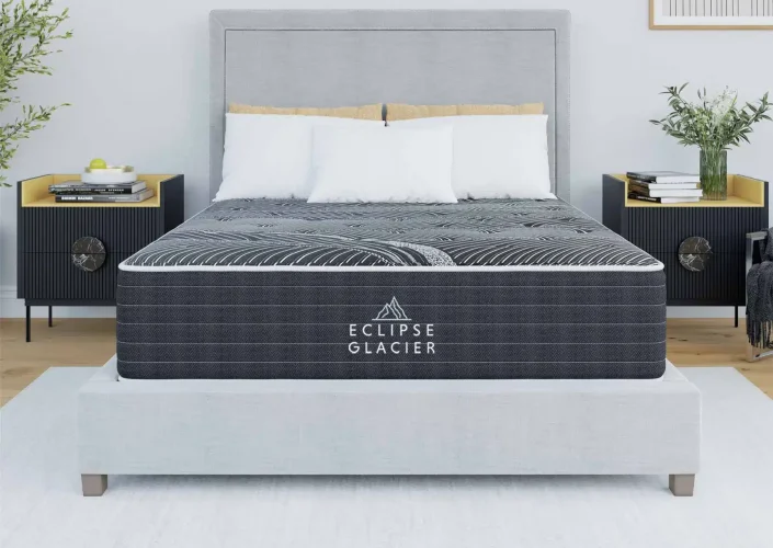 Eclipse Glacier mattress displayed on a modern bed frame, featuring a stylish design with a black and white pattern, surrounded by contemporary nightstands and decorative elements.
